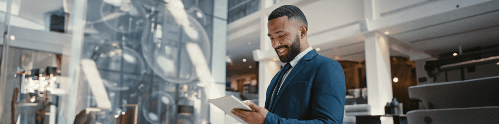 A man is smiling into his tablet.