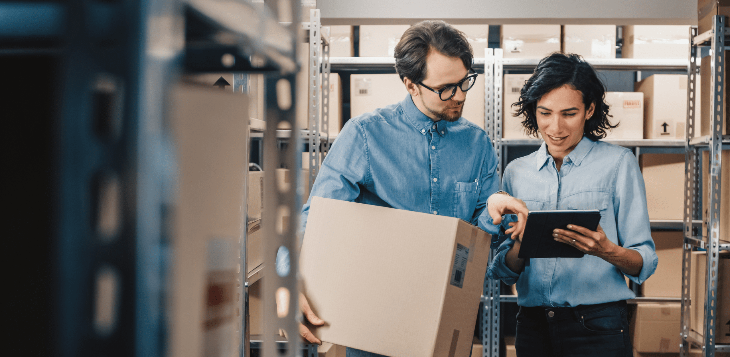 A man and a woman are talking in a storehouse.