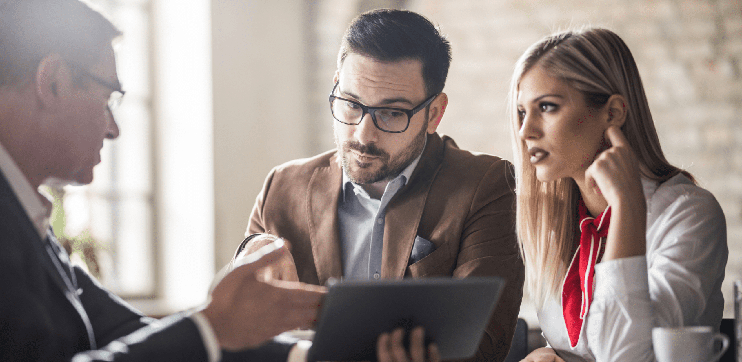 A man is looking into a tablet that is being held by a woman next to him.