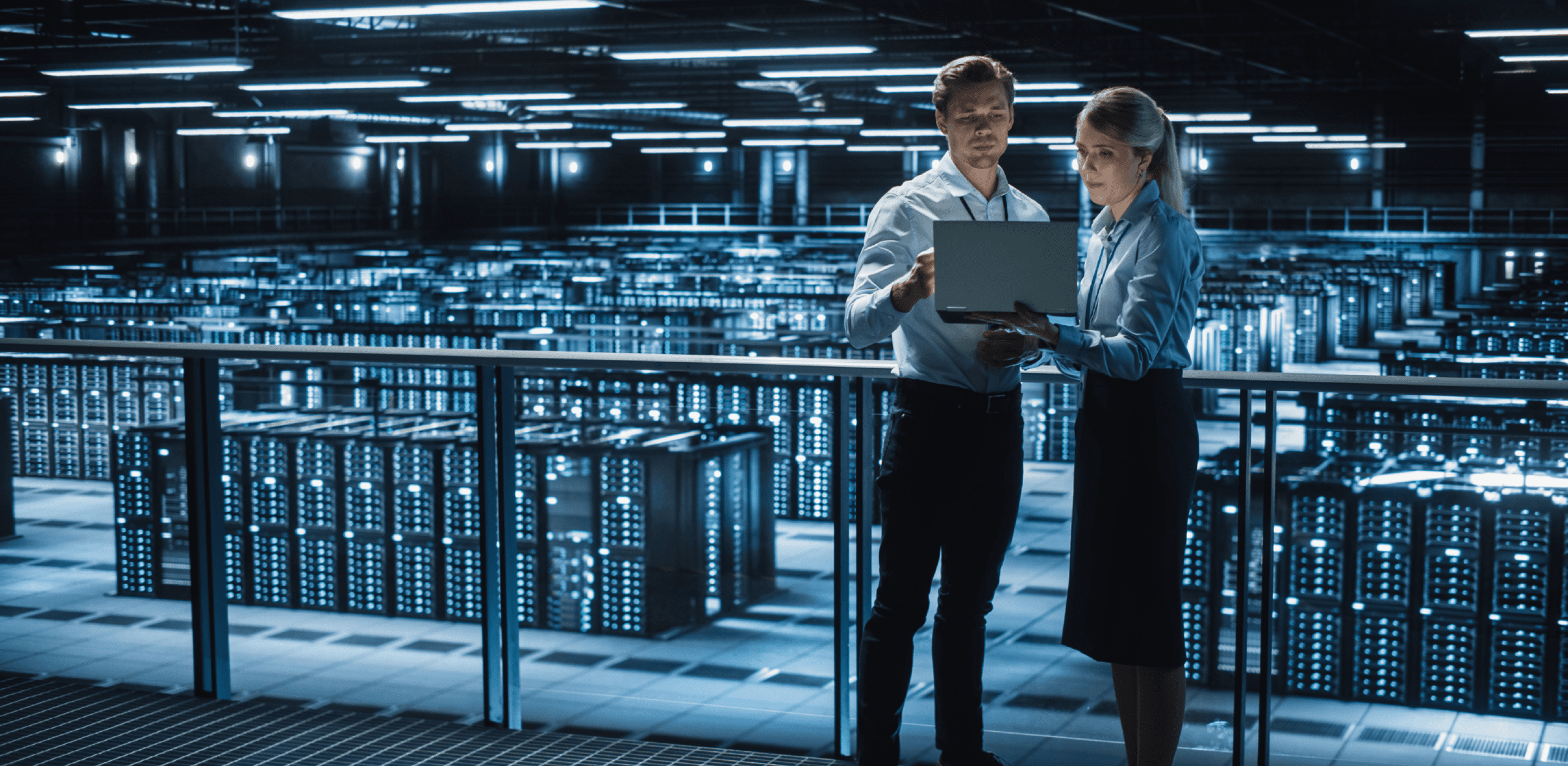 A man and a woman are looking into a laptop.